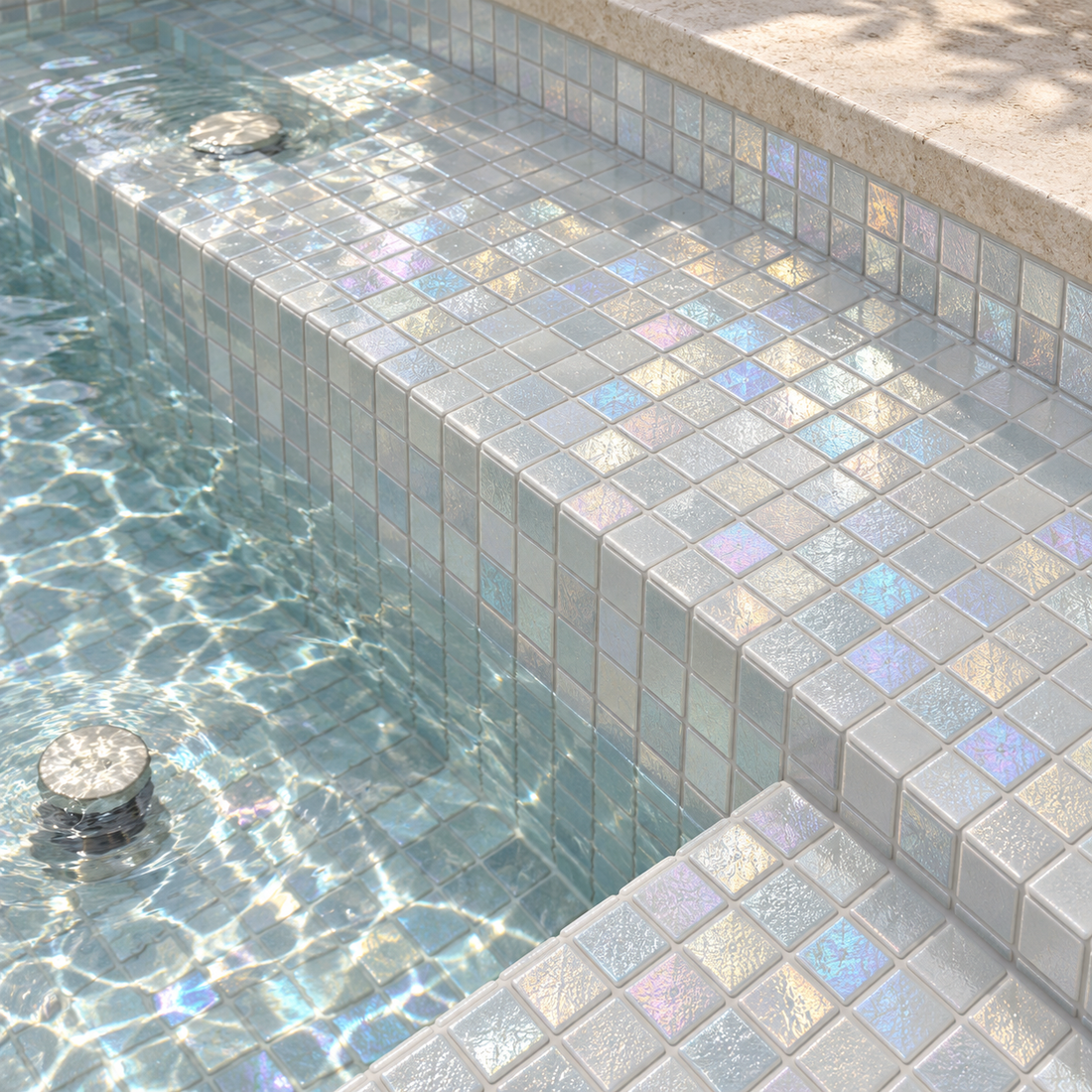 Abalone Pearl iridescent swimming pool mosaics on spa steps, with shimmering white square tiles, clear water and limestone edging