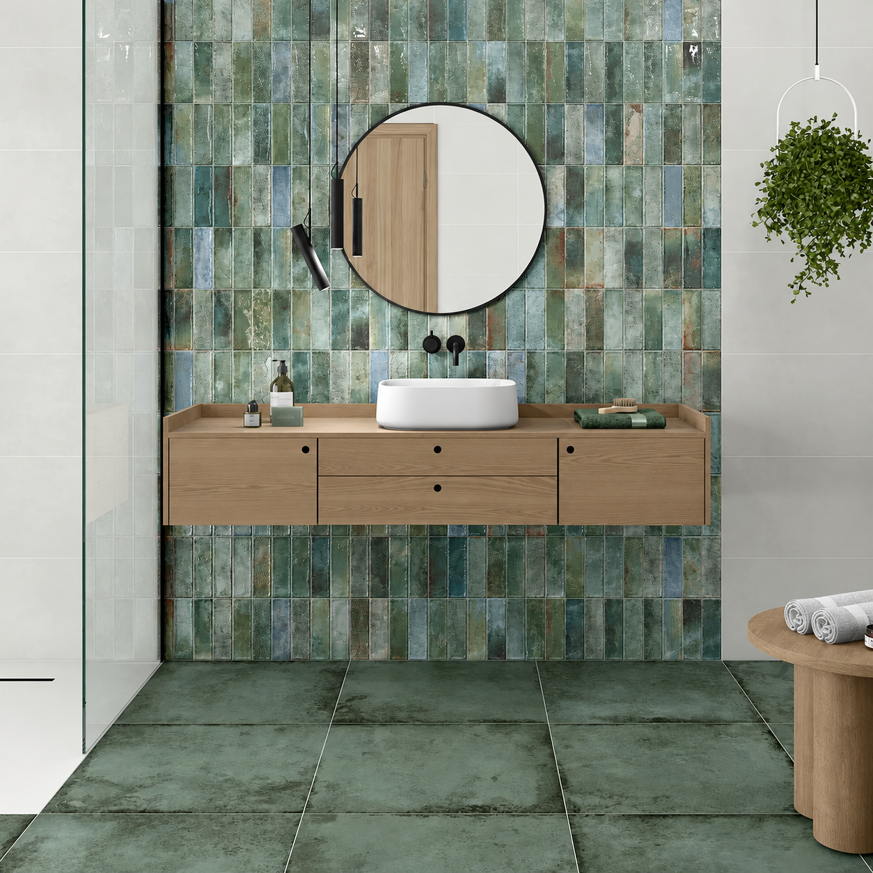 Alloy Mint metal effect porcelain floor tiles beneath an oak bathroom vanity with a round mirror and green tiled feature wall.