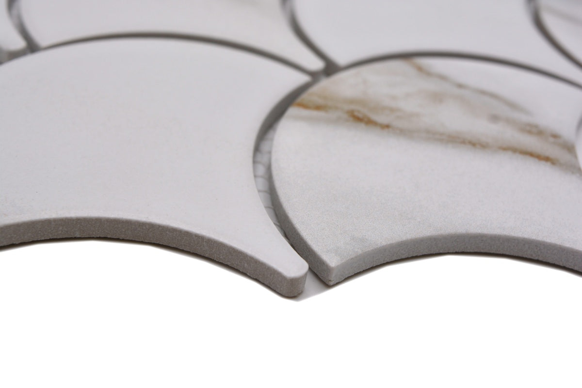 Close-up of Calacatta Gold marble effect scallop mosaic tile showing matt white ceramic surface, golden veining and curved fan-shaped edges