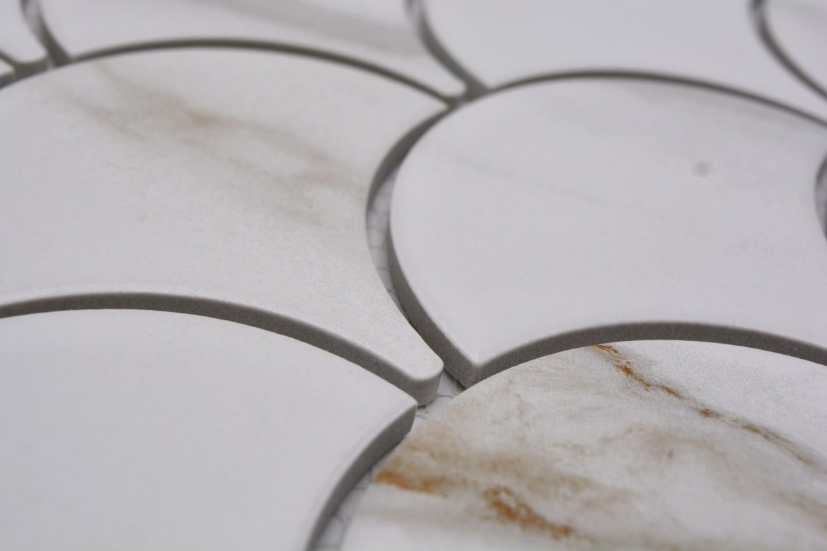 Detailed macro image of Calacatta Gold scallop mosaic tiles with 2mm grey grout joints and soft white marble effect finish