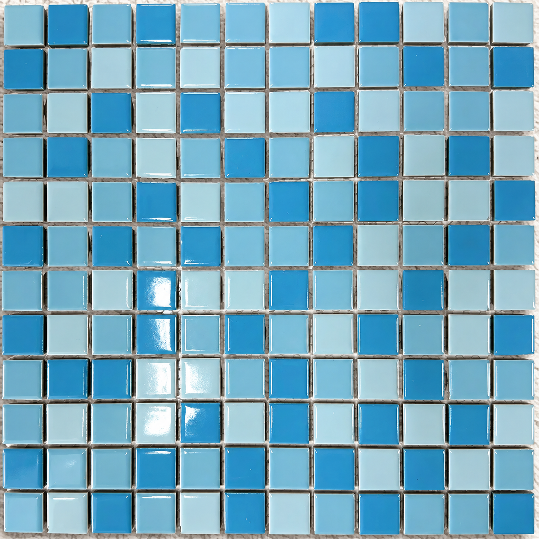 Swimming pool with curved steps clad in blue Ceramic Pool Mediterranean mosaic tiles and contrasting white edging.