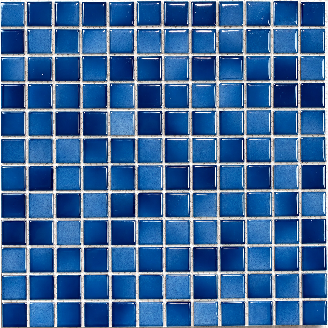 Close-up of Ceramic Pool Ocean Mosaic Tile showing 23mm blue squares with glossy highlights and subtly mottled surfaces.