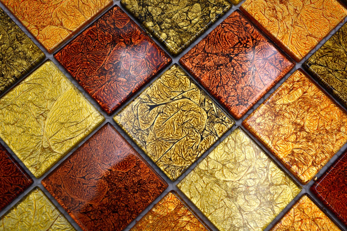 Close-up of glossy gold, copper and bronze mosaic tiles for kitchen and bathroom walls