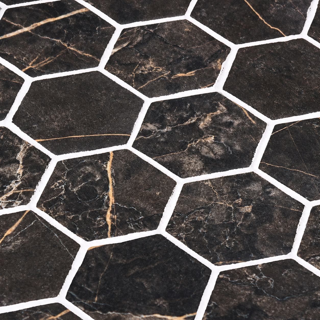 Close-up of Hex XL Coimbra dark matt hexagon mosaic tiles showing warm veining and contrasting white joints.
