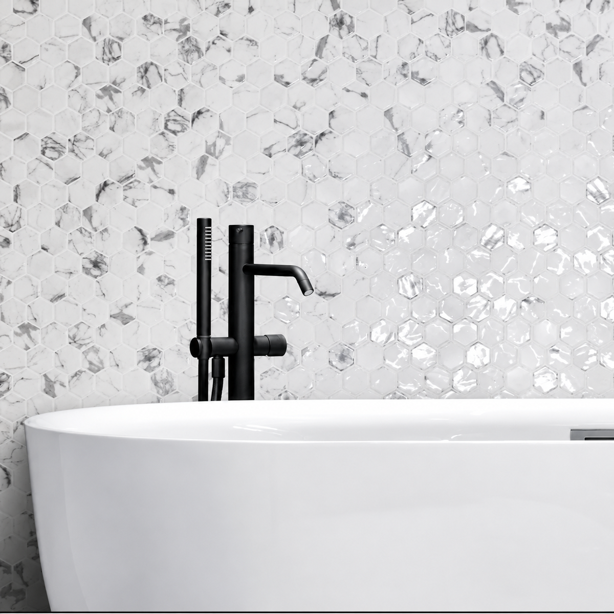 Hex XL Fosco white and grey marble-effect hexagon mosaic wall behind a freestanding bath with black tap.