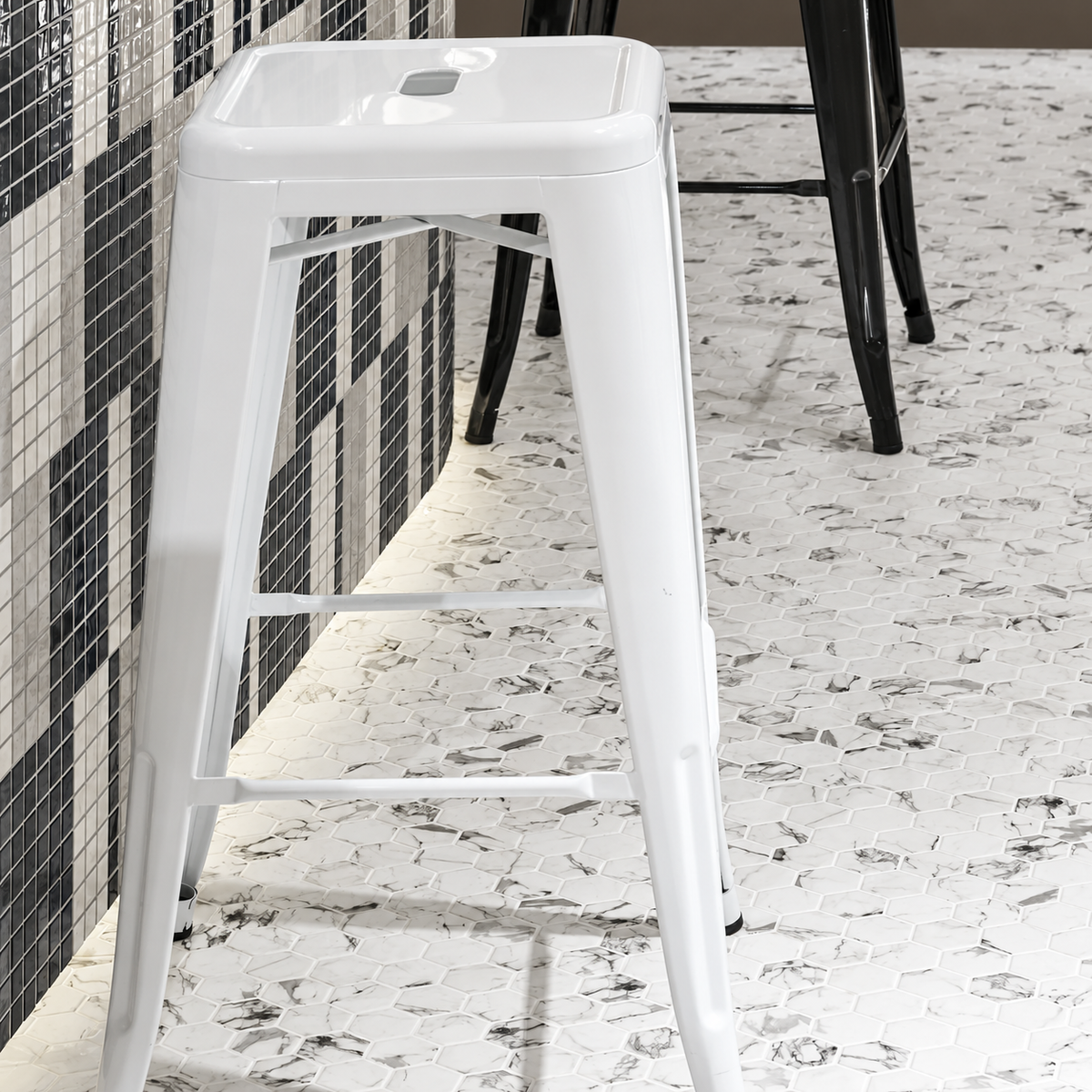 Hex XL Fosco marble-effect hexagon mosaic flooring beneath white and black stools beside a square mosaic counter.