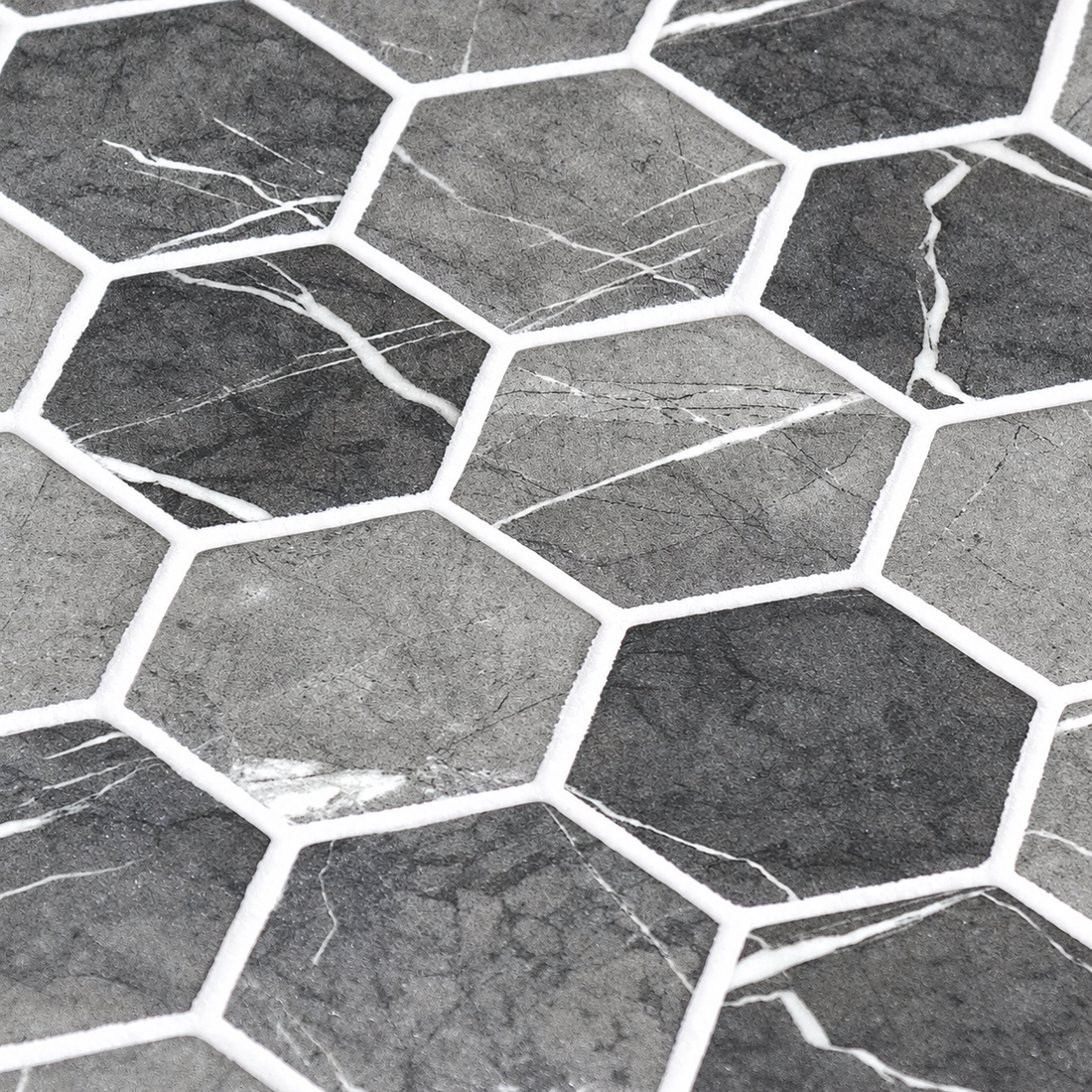 Close-up of Hex XL Grafito grey hexagon glass mosaics showing the matt finish, white marble-effect veins and white joints.