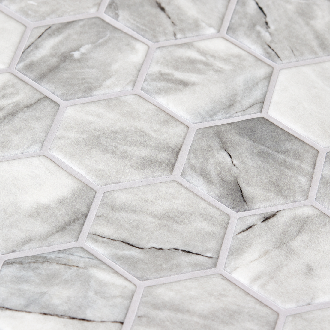 Close-up of Inverno Grey hexagon glass mosaics showing cloudy silver-grey markings, dark veins and a matt finish.