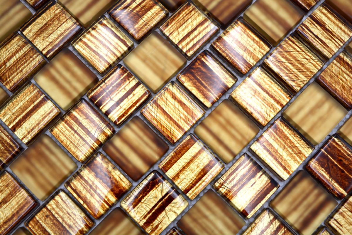 Close-up of Honey Bronze glass mosaic tiles showing glossy amber chips with metallic bronze linear streaks and reflective surface texture.
