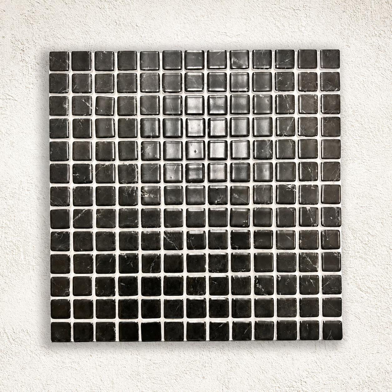 Karma Black Marble effect glass mosaic sheet with glossy black square tiles and fine white veining on a white textured background.