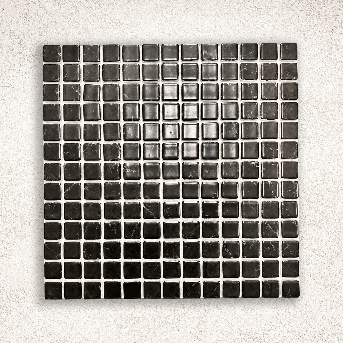 Karma Black Marble effect glass mosaic sheet with glossy black square tiles and fine white veining on a white textured background.