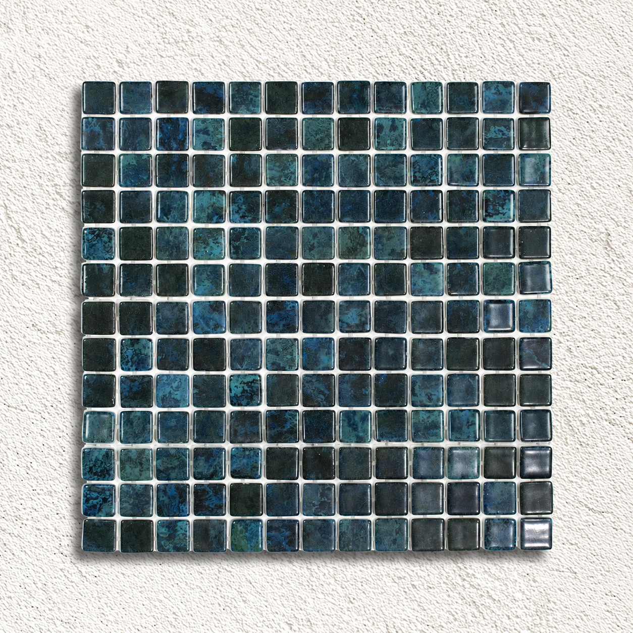 Karma Blue Moon glass mosaic sheet showing glossy 25mm squares in mottled dark blue, teal and charcoal.