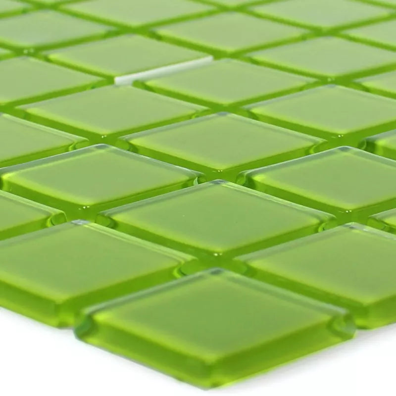 Close-up of lime green translucent glass mosaic tiles showing glossy raised 23x23mm square chips with light-reflective edges