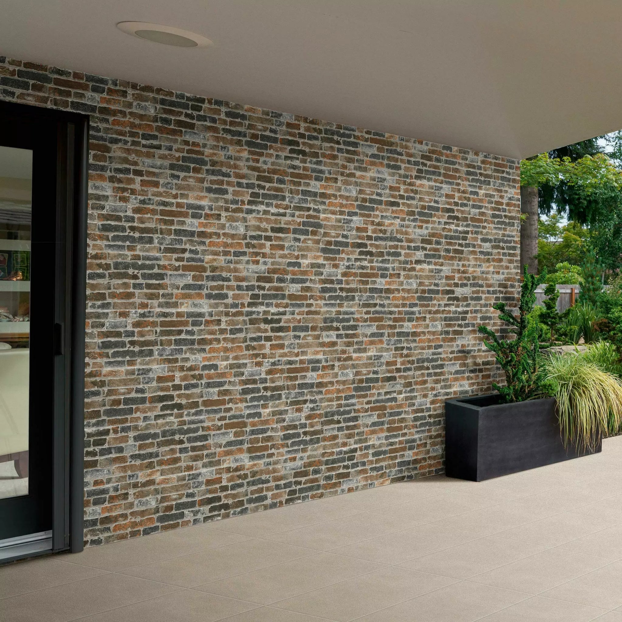 Modern outdoor setting with a textured brick wall and garden plants.