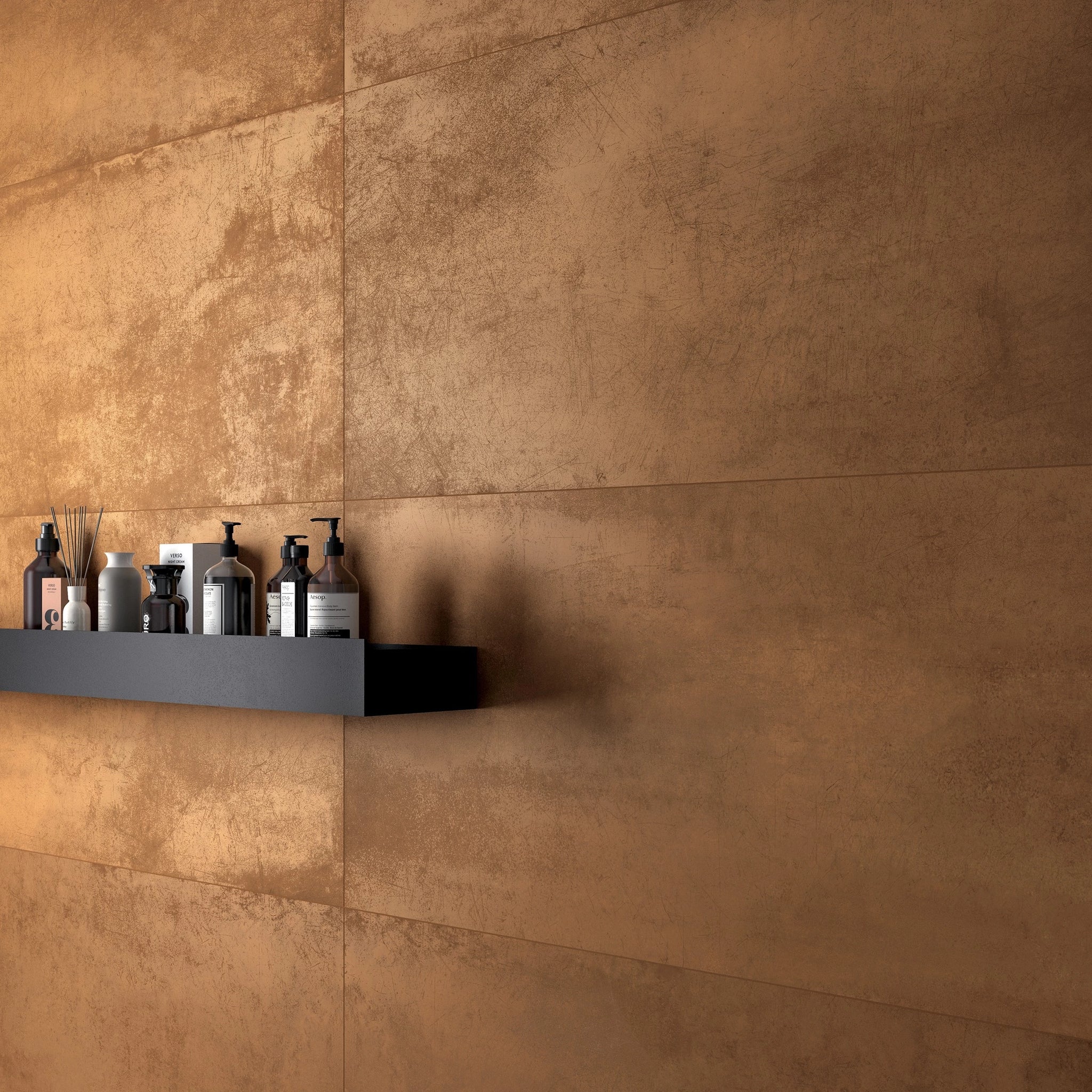 Milan Bronze metal effect porcelain tiles installed on a bathroom wall with matt aged bronze surface and black shelf styling