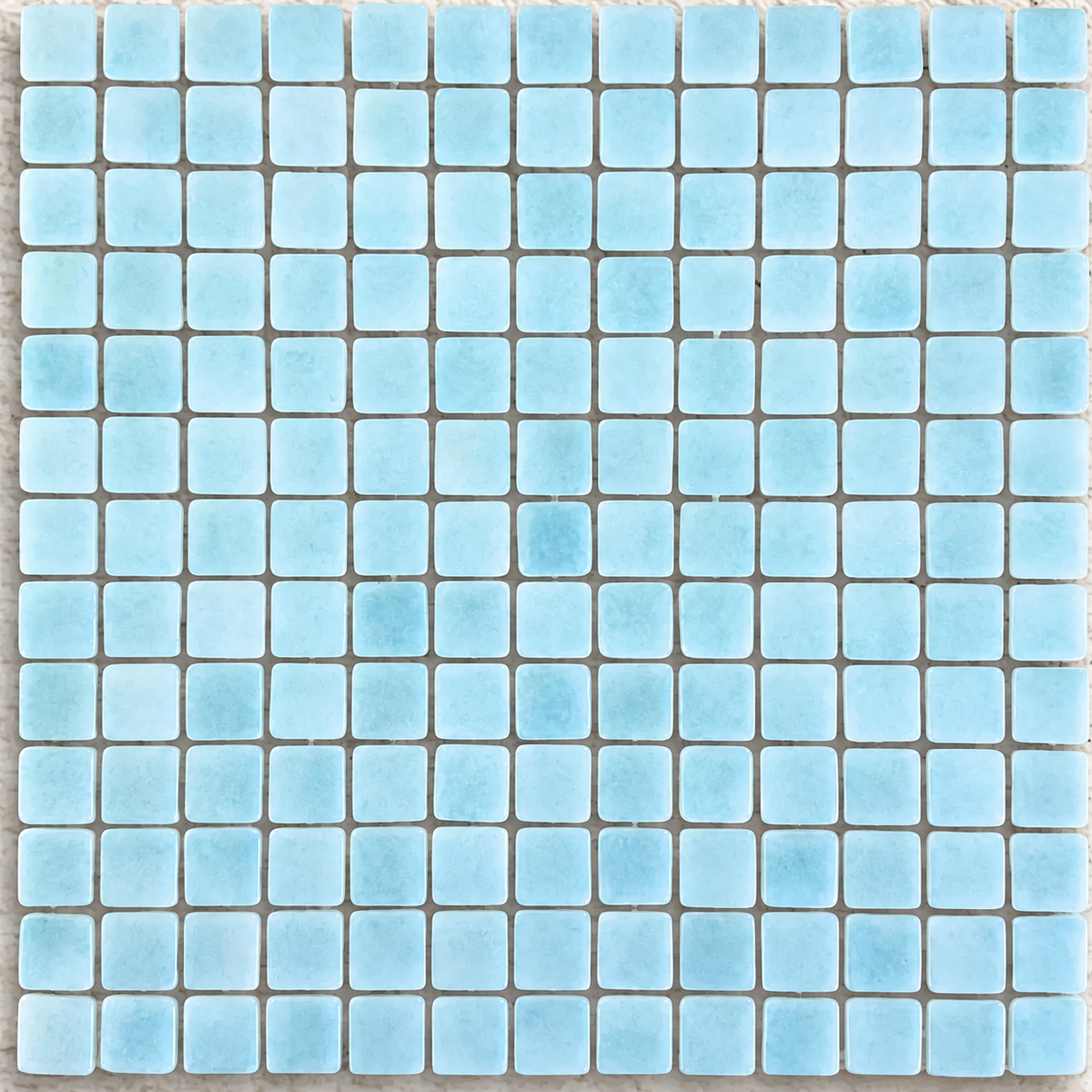 Detail of Niebla Foggy Aqua gloss glass mosaics showing cloudy pale blue markings and softly rounded square edges.