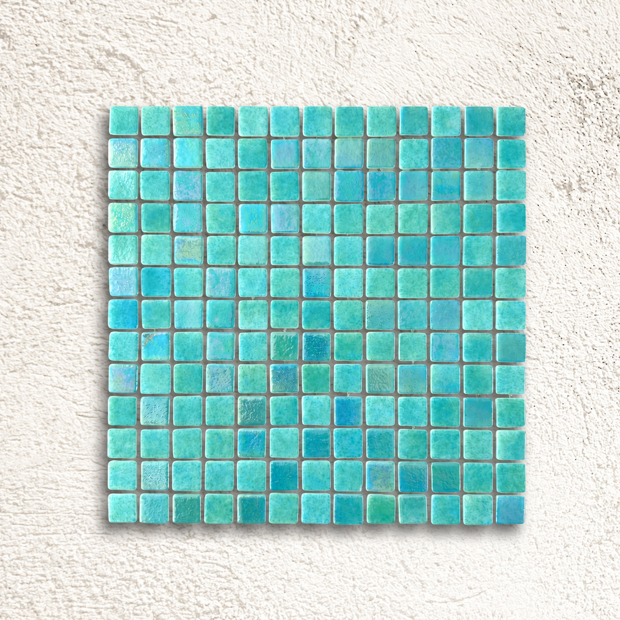 Niebla Mix-Iris Indo green glass mosaic sheet with turquoise tones and iridescent accents against a white textured background.