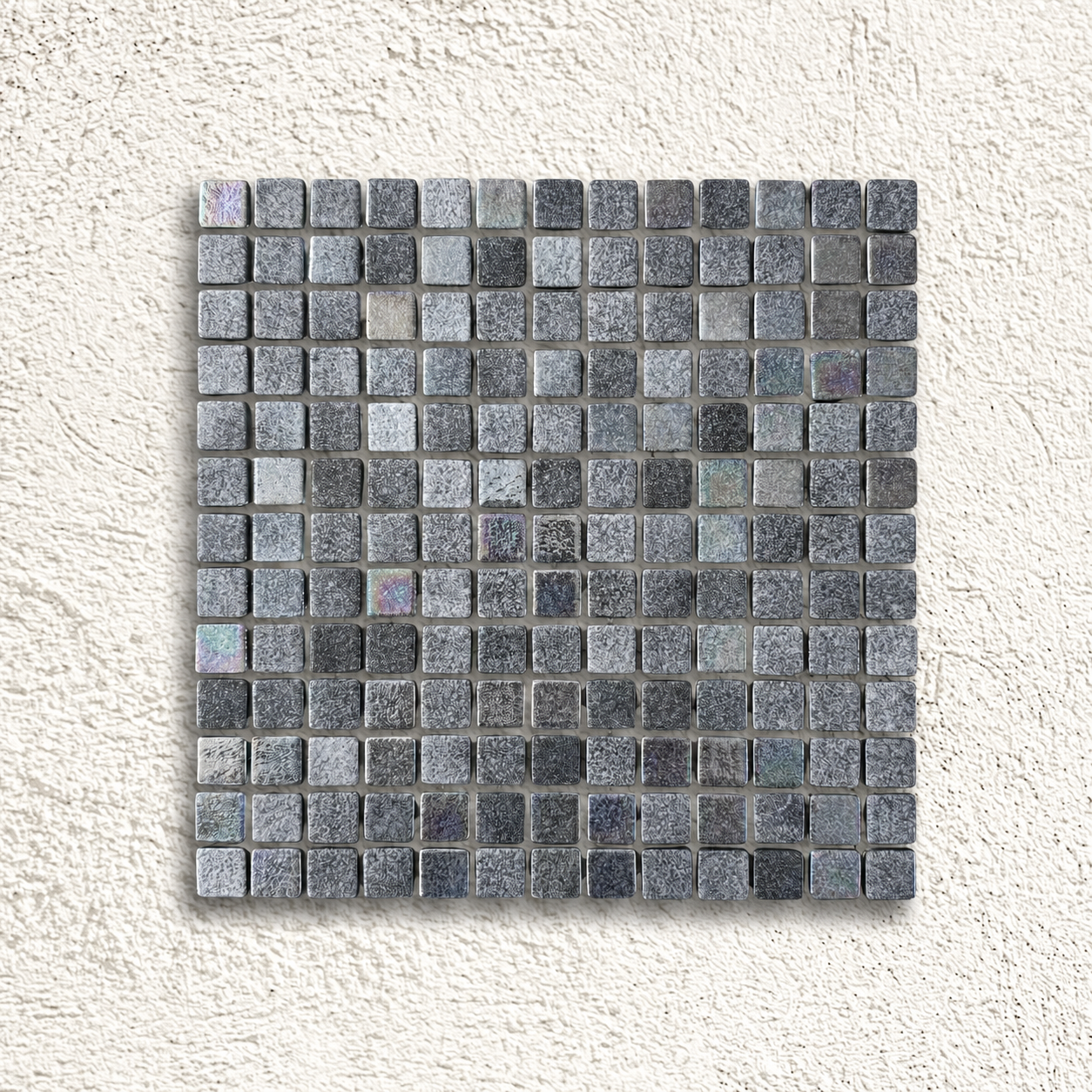 Niebla Mix-Iris Murray black and grey glass mosaic sheet with subtle iridescent highlights on a white textured background.