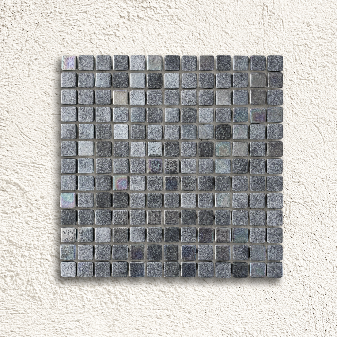 Niebla Mix-Iris Murray black and grey glass mosaic sheet with subtle iridescent highlights on a white textured background.