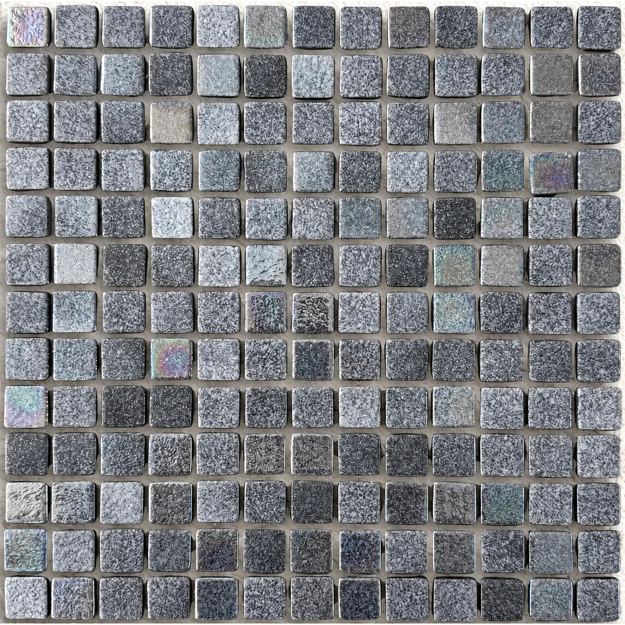 Close Up of Niebla Mix-Iris Murray square glass mosaic tiles showing mottled charcoal and grey tones with a lustre finish.