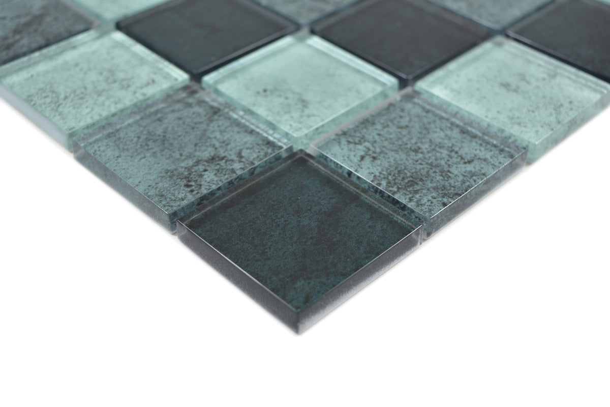 Close-up of Raindrop petrol and mint green glass mosaic tiles with translucent edges and fine speckled texture.