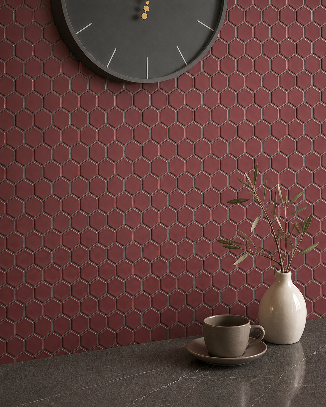 Shapes Hexagon Gloss Burgundy Red Mosaic Tile splashback with dark grey grout, marble worktop, charcoal clock and ivory vase with olive stems.