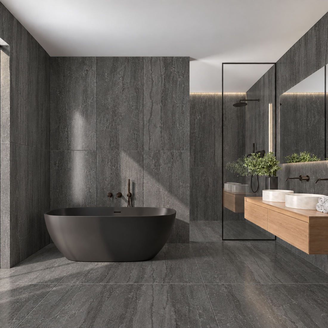Siena Anthracite travertine effect tiles on bathroom walls and floor with a black freestanding bath, oak vanity and glass shower enclosure