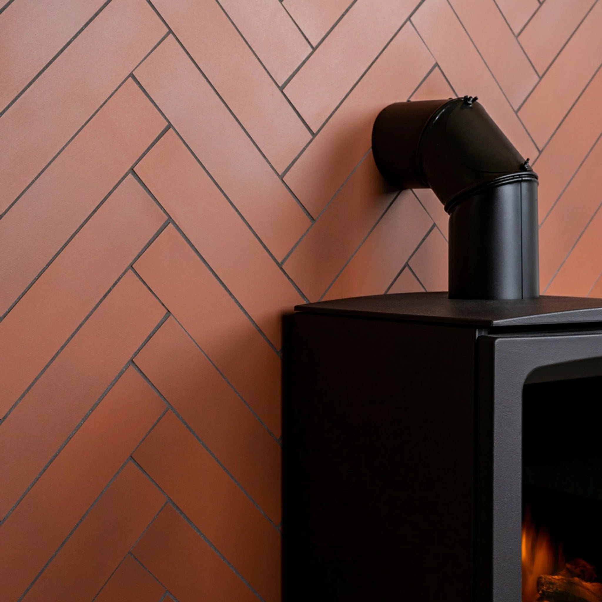 Black stove with a chimney against a brick wall