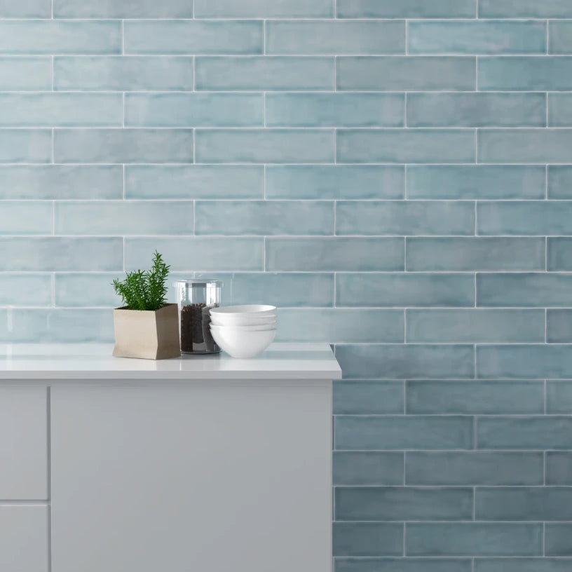 Glacier Sky glossy metro tiles creating a calm spa-like bathroom feature wall, with cool blue tones enhanced by reflective light movement.